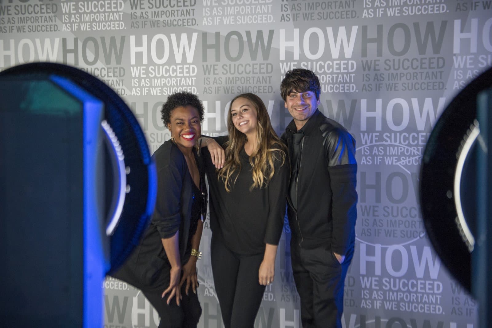 Guests posing between two photo booths at the Baird 100-year celebration