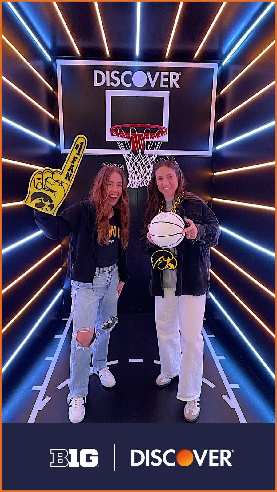 A wrapped Selfie Station photo kiosk with a basketball hoop set at a Big Ten fan event