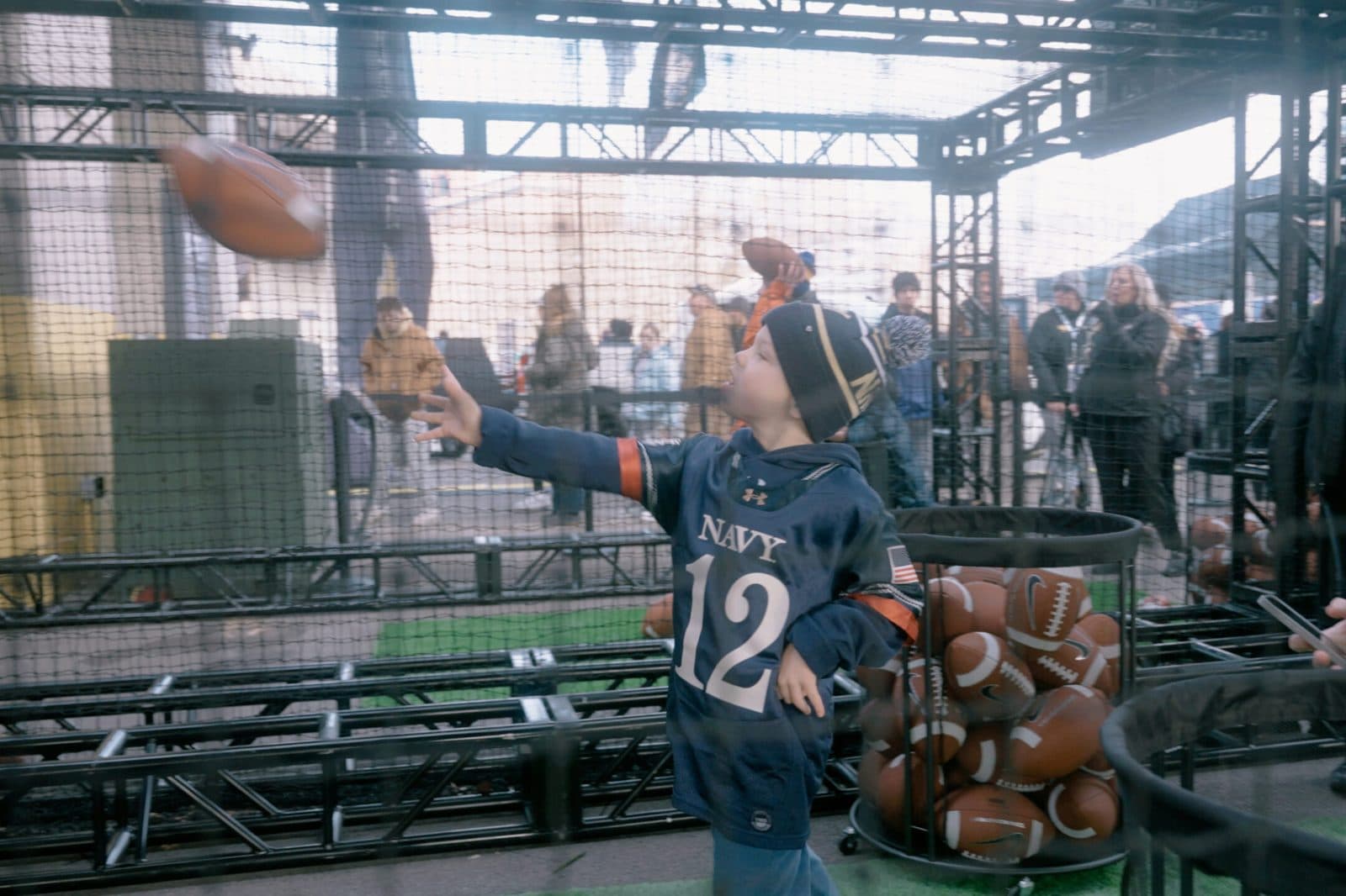 Young fan throwing a football in the Chevy Game Day Challenge cage at the Army-Navy Game